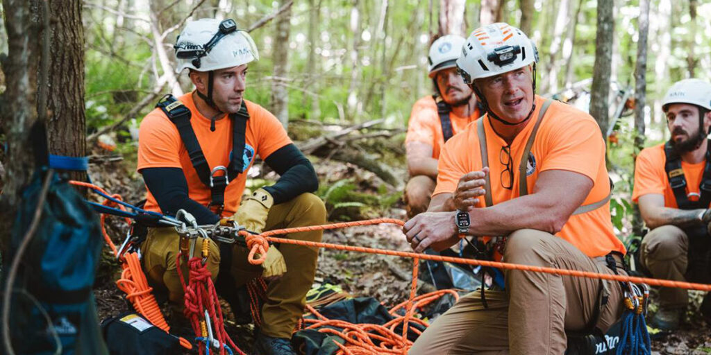 Wolfe County Search and Rescue personnel crouching in the woods