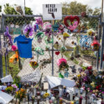 Memorial of Marjory Stoneman Douglas High School attack. Fence with flowers, candles, and notes.