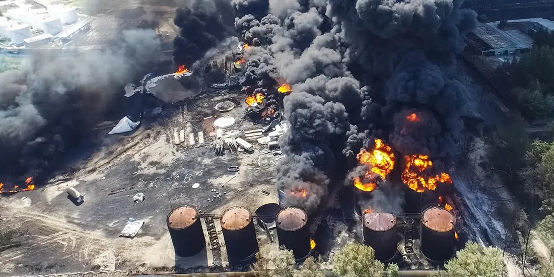 Oil storage fire. A tank farm is burning, dark smoke is combusting