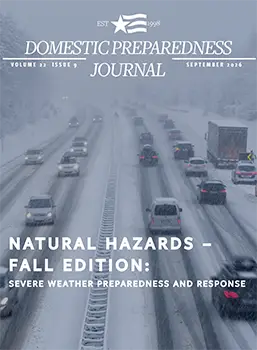 Four lanes of traffic on a snow-covered highway. A tractor-trailer and two cars are stopped on the side of the road as the snow continues to fall.